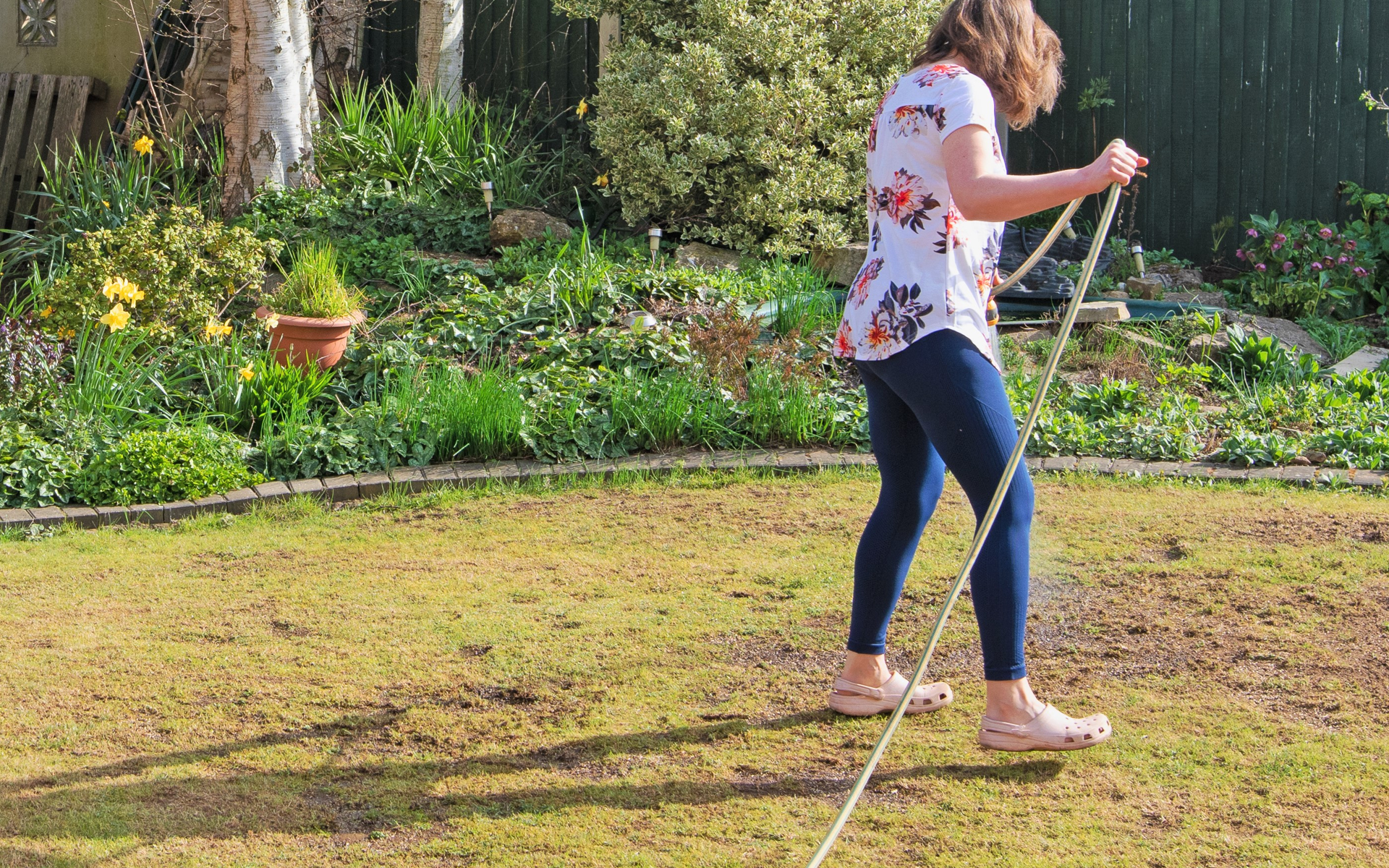 Woman working on spraying a warm weather lawn pests